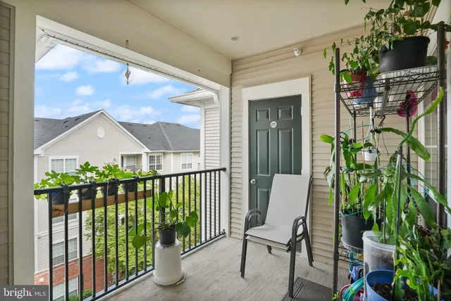 a view of a porch with chairs and potted plants