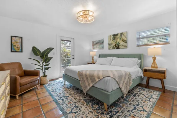 a view of a house with a yard and palm trees