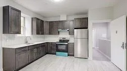 a kitchen with stainless steel appliances granite countertop a refrigerator and a sink
