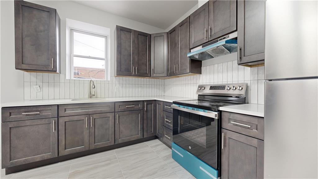 7902 16th Avenue Brooklyn, NY 11214 - Photo 10 of 17 a kitchen with stainless steel appliances granite countertop a sink stove and refrigerator
