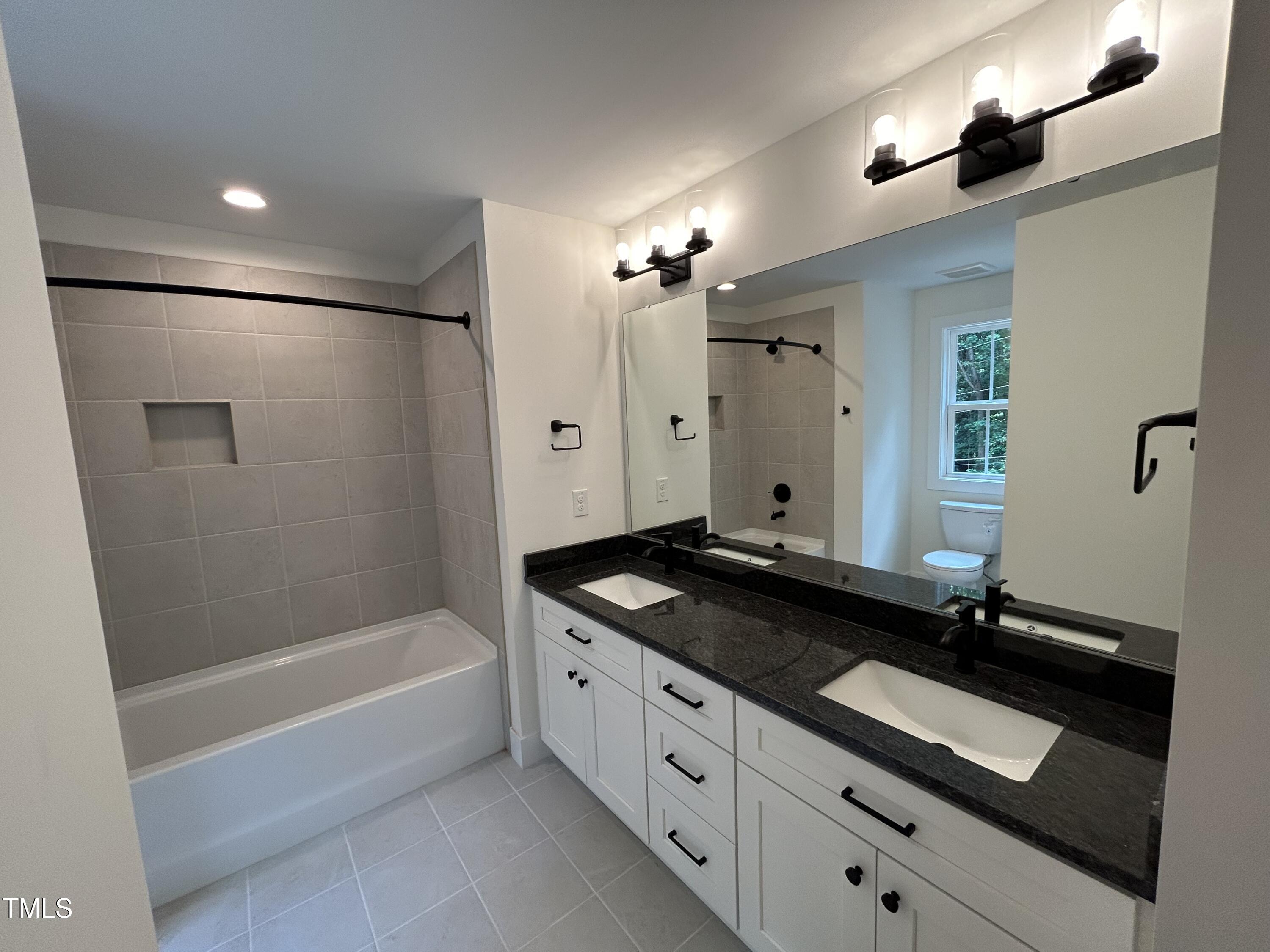 701 Locust Lane Raleigh, NC 27603 - Photo 15 of 19 a spacious bathroom with a granite countertop sink a mirror a bathtub and shower