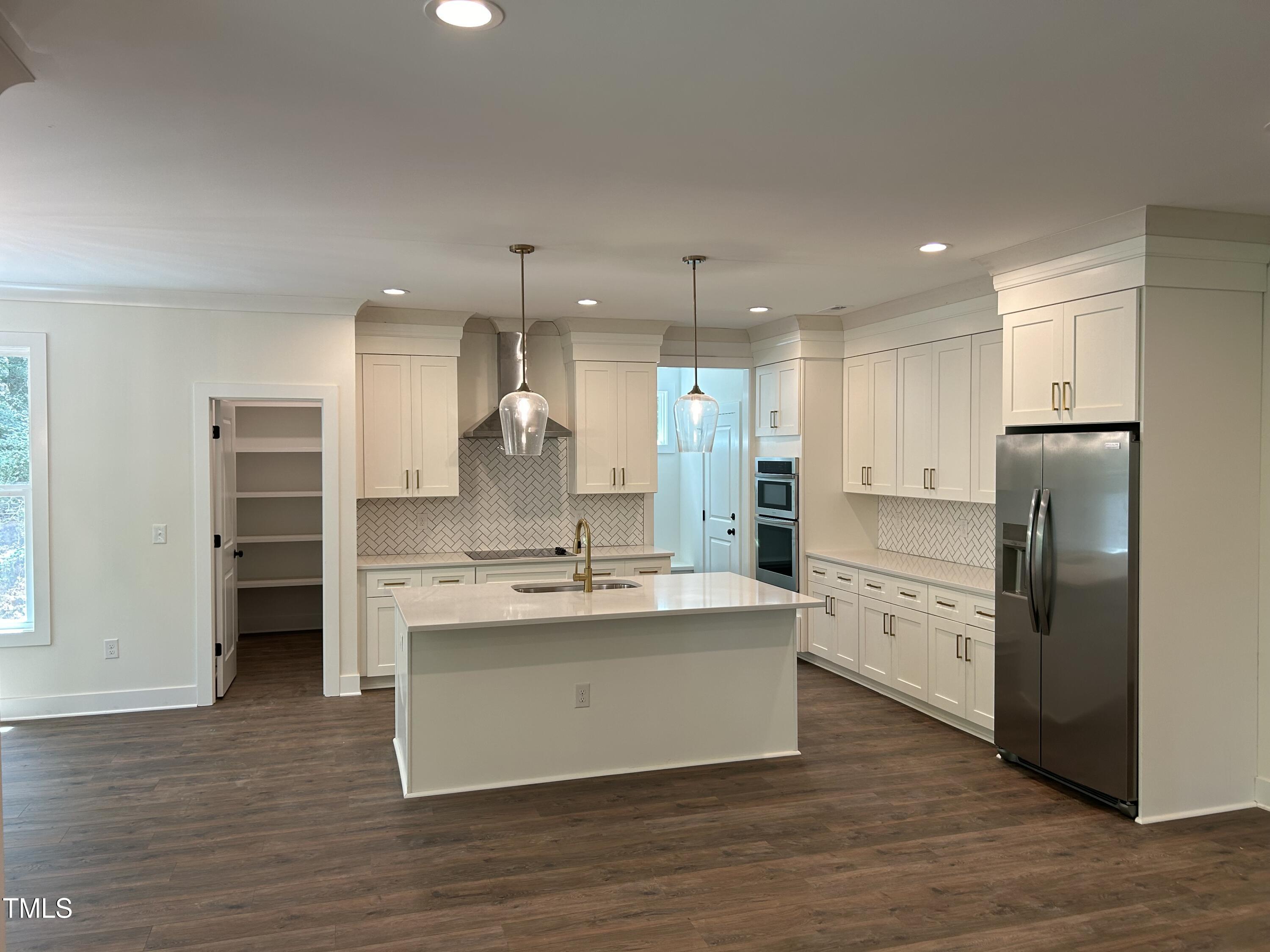701 Locust Lane Raleigh, NC 27603 - Photo 2 of 19 a large kitchen with stainless steel appliances a large counter top a sink and a refrigerator