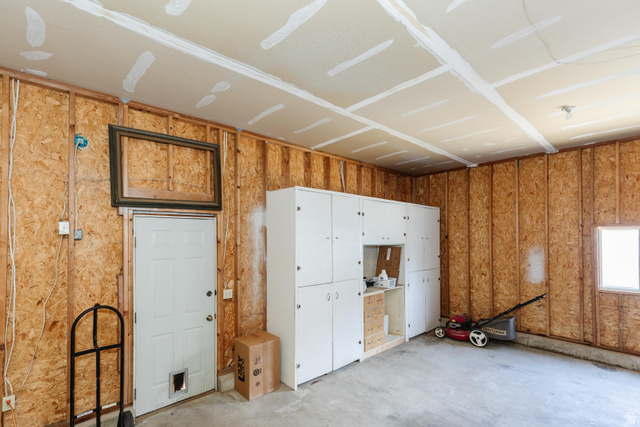 342 East 600 North Logan, UT 84321 - Photo 10 of 23 Unfinished garage interior featuring a concrete floor, exposed wood-panel walls, and a finished ceiling