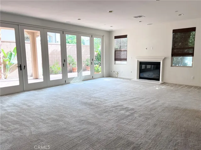 a view of an empty room with a fireplace and a window
