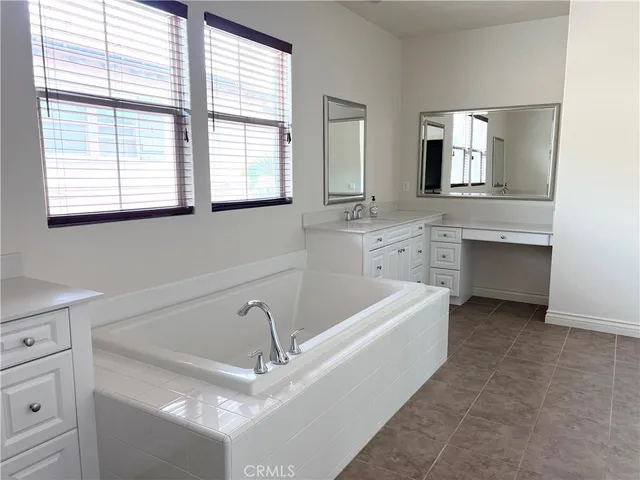 a spacious bathroom with a bathtub sink and mirror
