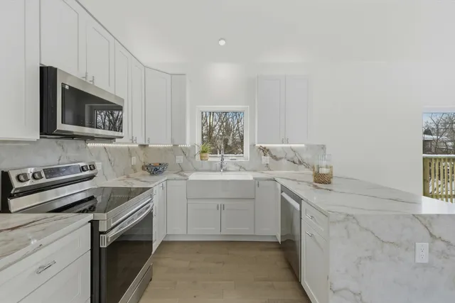 a kitchen with granite countertop a sink stove and microwave