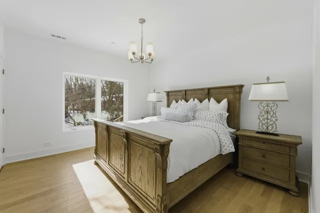 a spacious bedroom with a bed and wooden floor