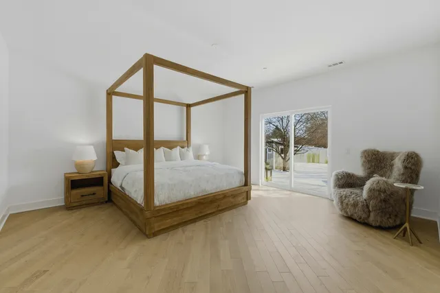 a spacious bedroom with a bed and a mirror