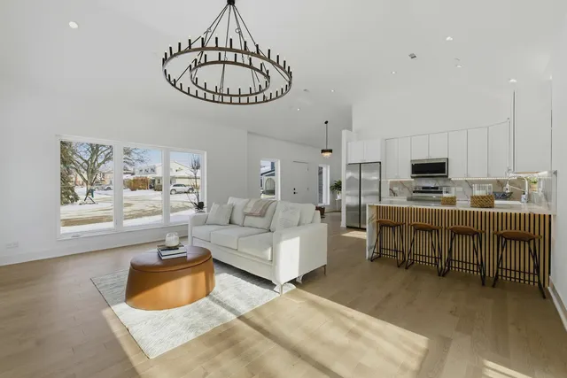 a living room with furniture a table and kitchen view