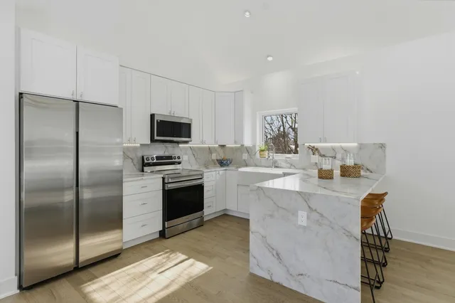 a kitchen with a refrigerator and a stove top oven