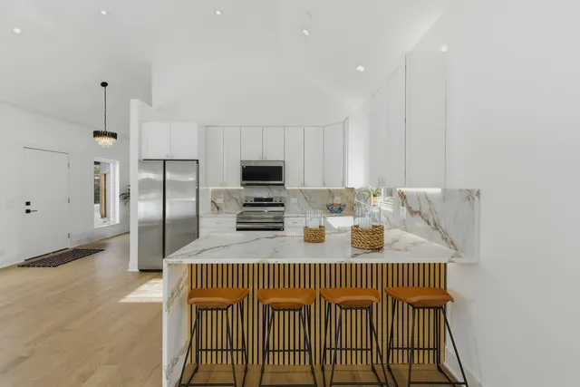 a kitchen with stainless steel appliances granite countertop a sink refrigerator and microwave