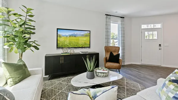 a living room with furniture potted plant and a window