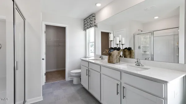 a bathroom with a double vanity sink mirror and toilet