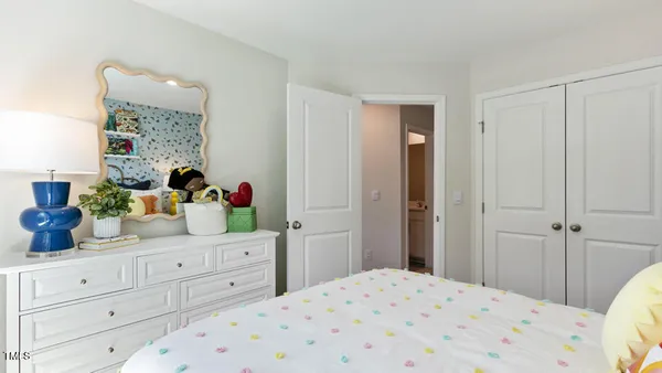 a bedroom with a large bed and a dresser