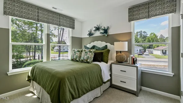 a bed sitting in a bedroom next to a window