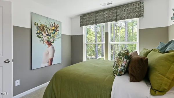 a bed sitting in a bedroom next to a window