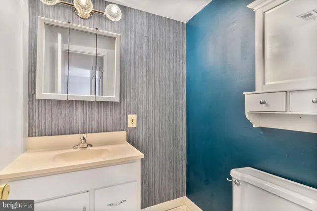 a bathroom with a sink a toilet and a mirror