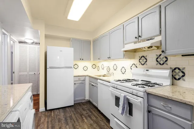 a kitchen with granite countertop a sink stove and refrigerator