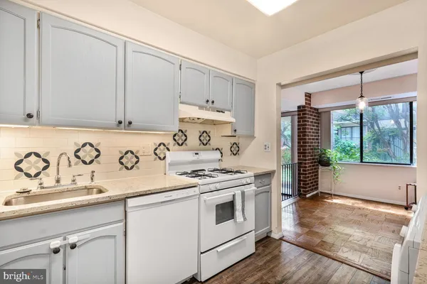 a kitchen with granite countertop white cabinets and white appliances