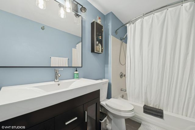 a bathroom with a sink a toilet and shower curtain