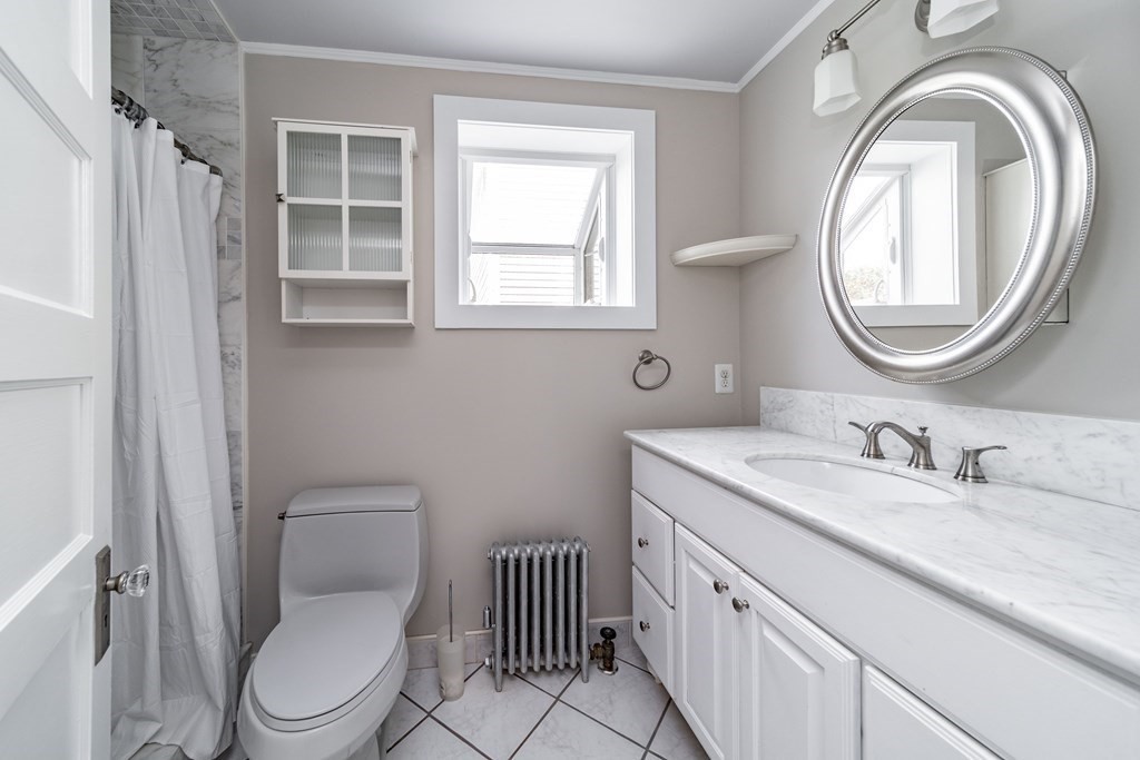 120 Winton Street Springfield, MA 01118 - Photo 10 of 25 a bathroom with a granite countertop toilet a sink and a mirror