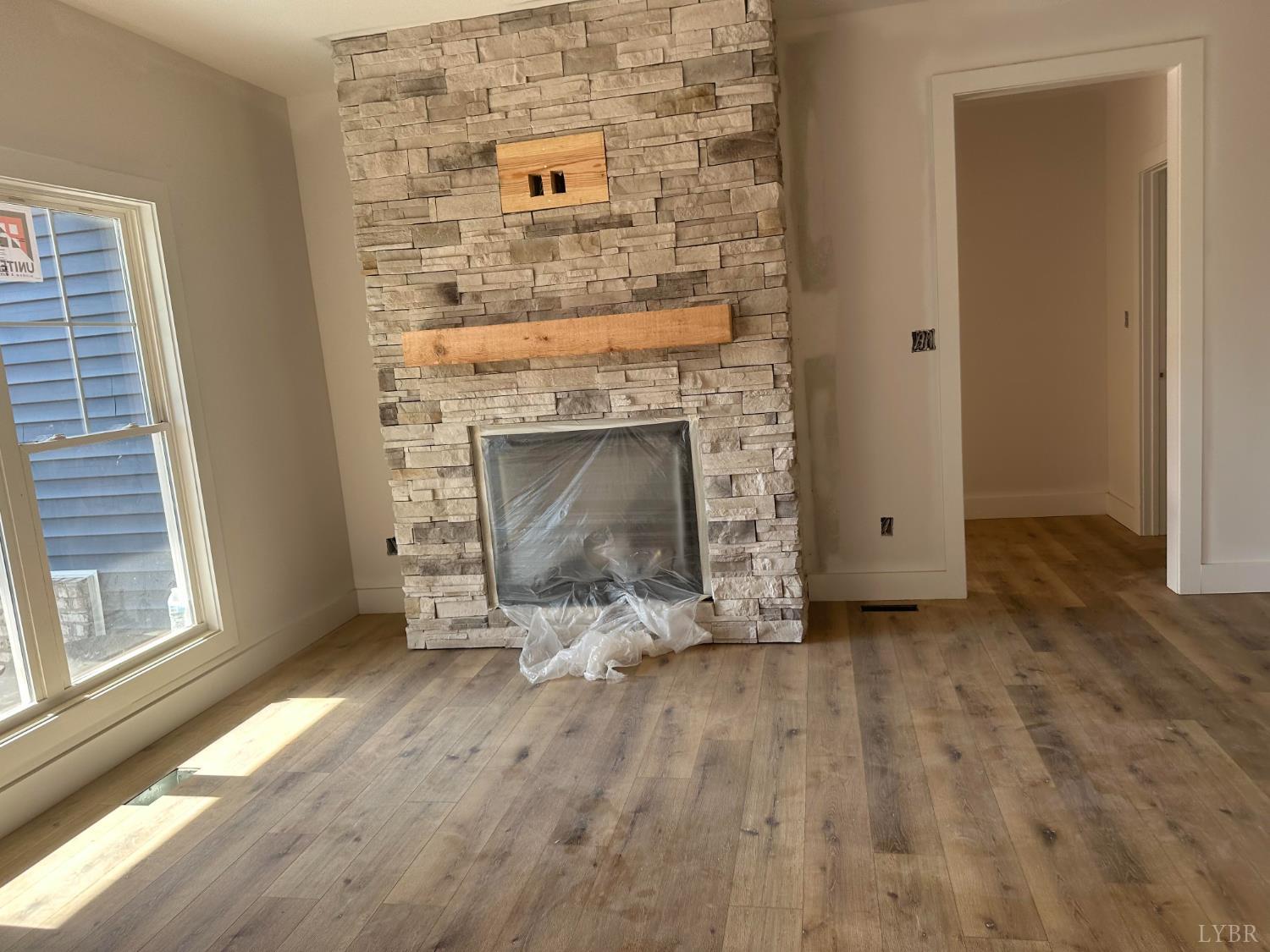 2515 English Tavern Road Lynchburg, VA 24501 - Photo 4 of 6 an empty room with wooden floor fireplace and windows