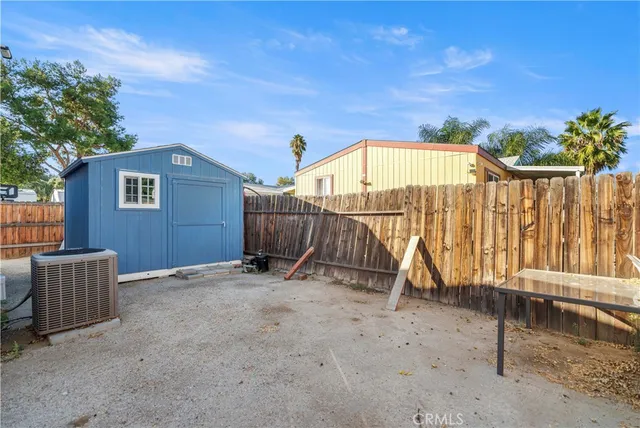 a view of backyard with small cabin and wooden fence