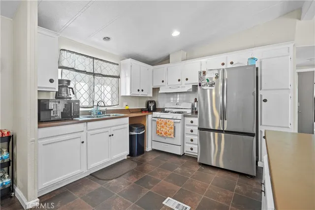 a kitchen with white cabinets and white stainless steel appliances