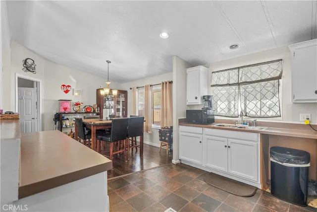 a large white kitchen with lots of counter top space and stainless steel appliances