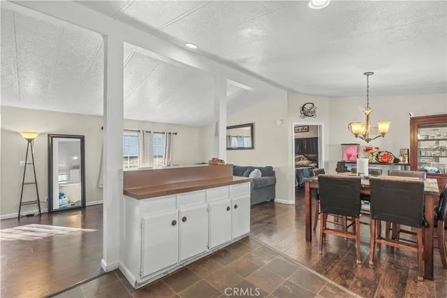 a kitchen with a dining table chairs and white cabinets