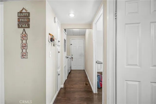 a view of a hallway with wooden floor and closet