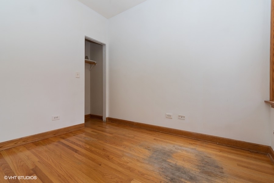 819 South Carpenter Street, Unit 3R Chicago, IL 60607 - Photo 7 of 10 an empty room with wooden floor and fan