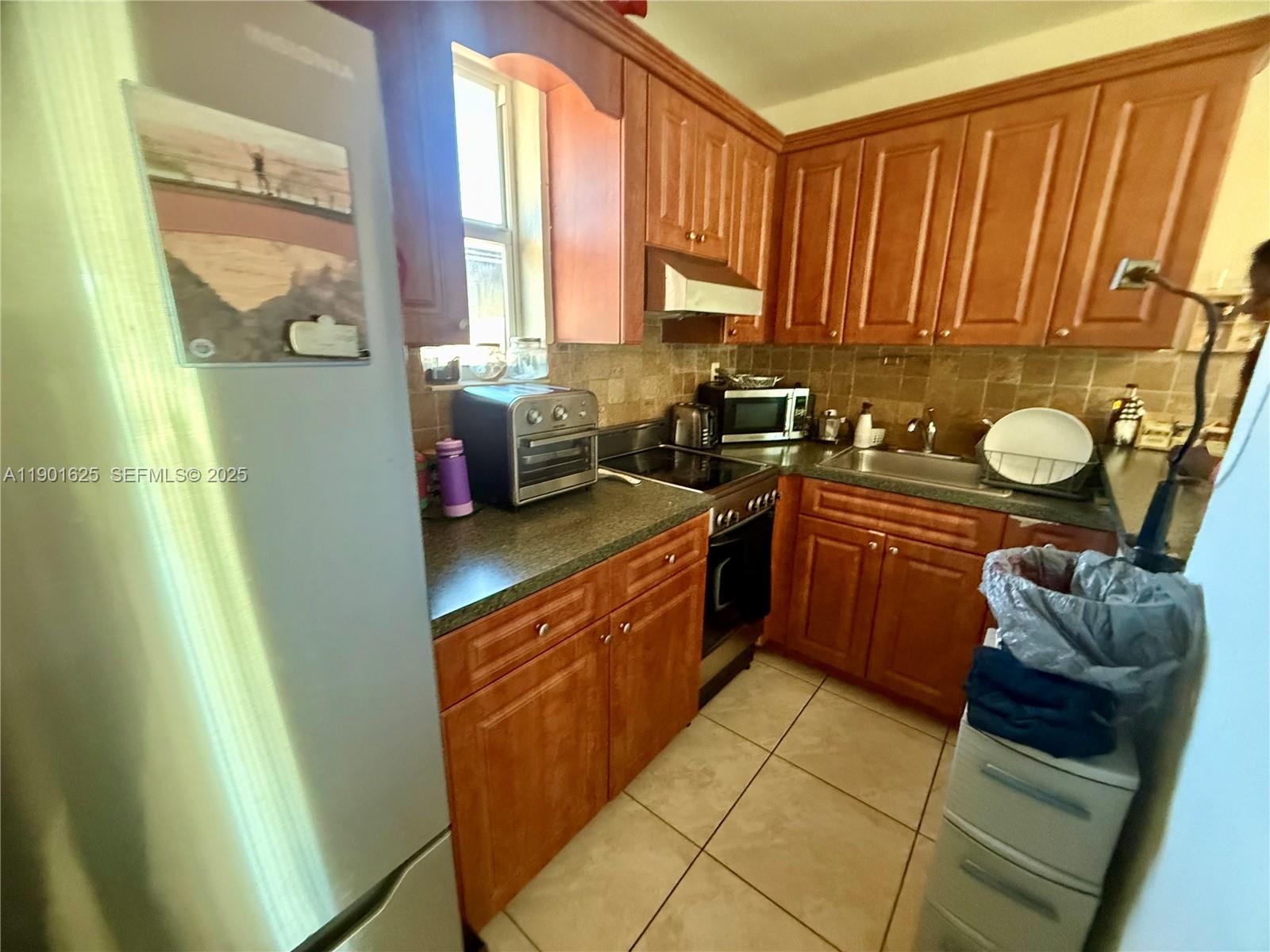 4201 Southwest 7th Street Miami, FL 33134 - Photo 12 of 23 a kitchen with a sink a window and cabinets