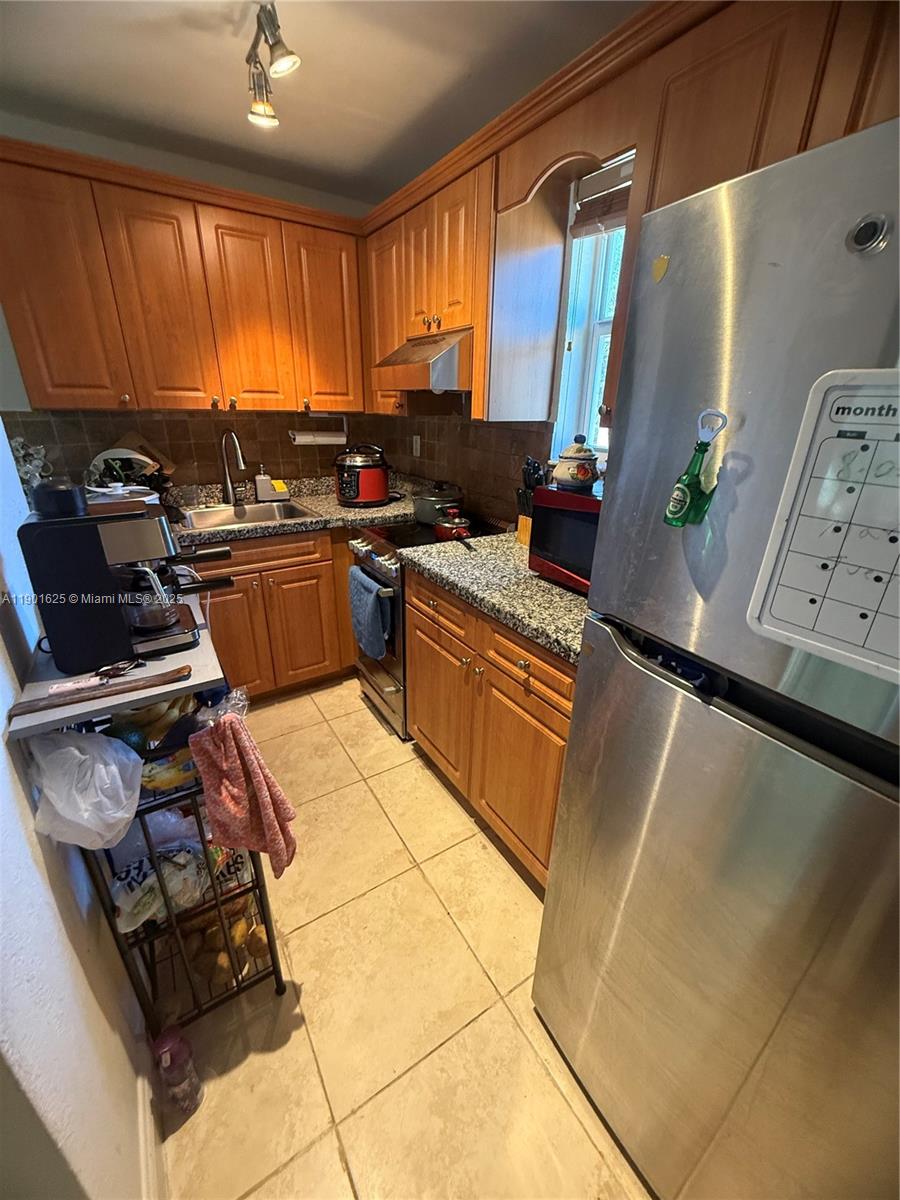 4201 Southwest 7th Street Miami, FL 33134 - Photo 13 of 23 a kitchen with stainless steel appliances granite countertop a sink stove and cabinets