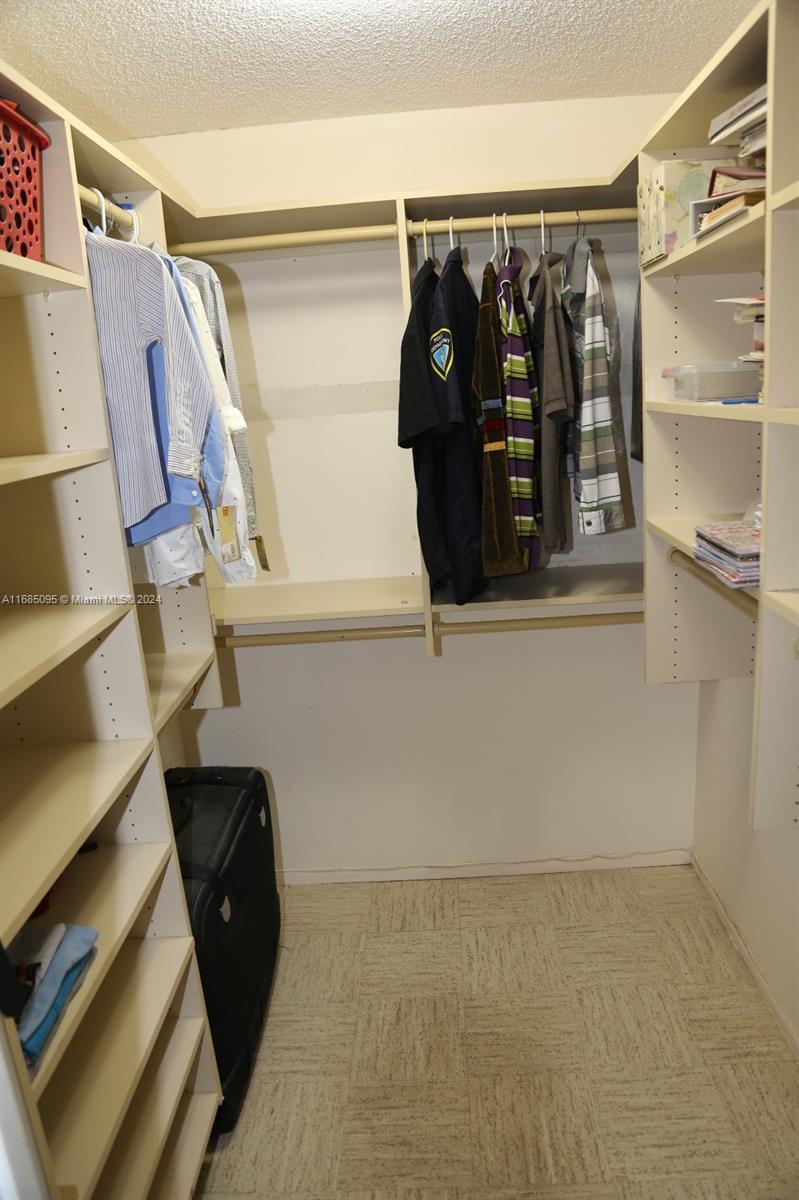 800 Northeast 195th Street, Unit 501 Miami, FL 33179 - Photo 19 of 39 a view of walk in closet with clothes and shoes