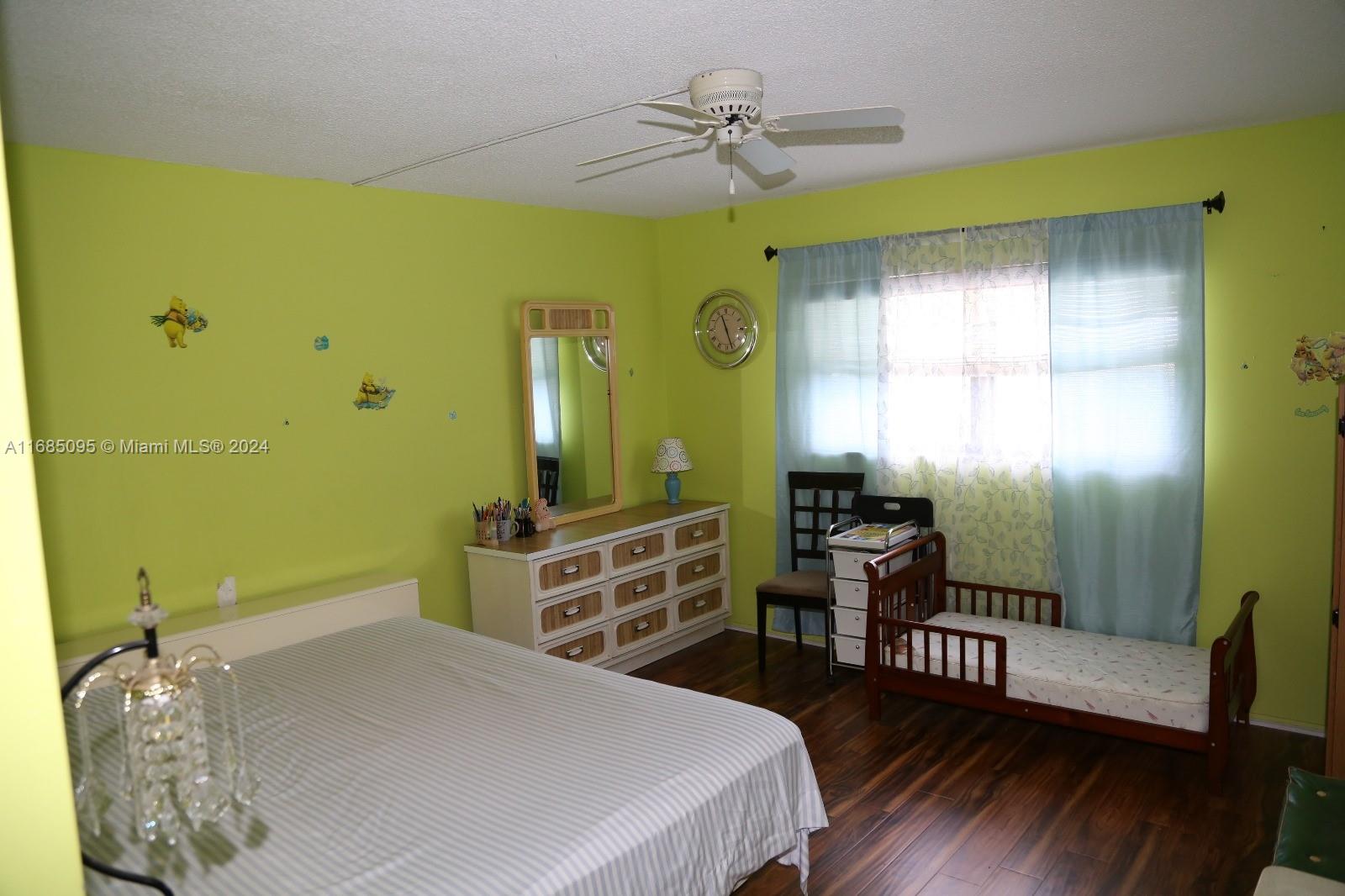 800 Northeast 195th Street, Unit 501 Miami, FL 33179 - Photo 20 of 39 a bedroom with a bed and wooden floor