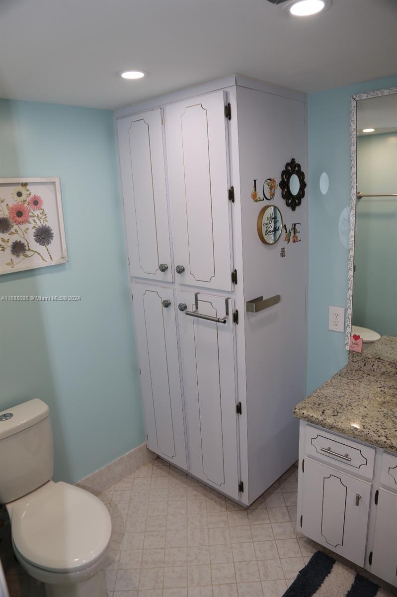 800 Northeast 195th Street, Unit 501 Miami, FL 33179 - Photo 22 of 39 a bathroom with a granite countertop sink toilet and shower