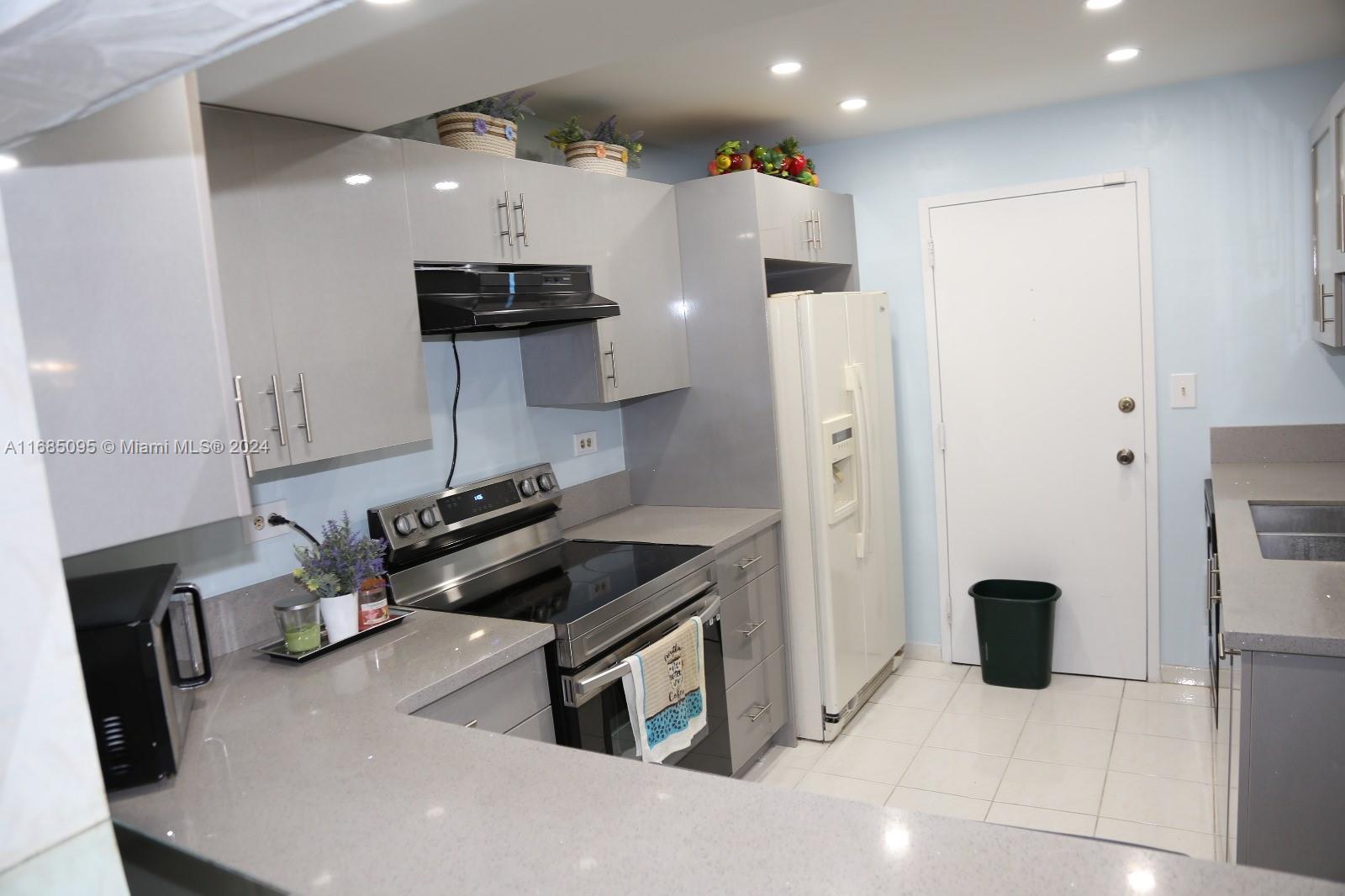 800 Northeast 195th Street, Unit 501 Miami, FL 33179 - Photo 5 of 39 a kitchen with stainless steel appliances granite countertop a refrigerator and a stove top oven