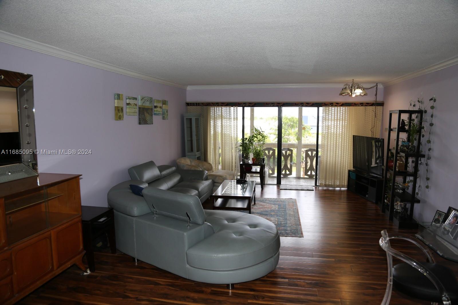 800 Northeast 195th Street, Unit 501 Miami, FL 33179 - Photo 6 of 39 a living room with furniture and a flat screen tv
