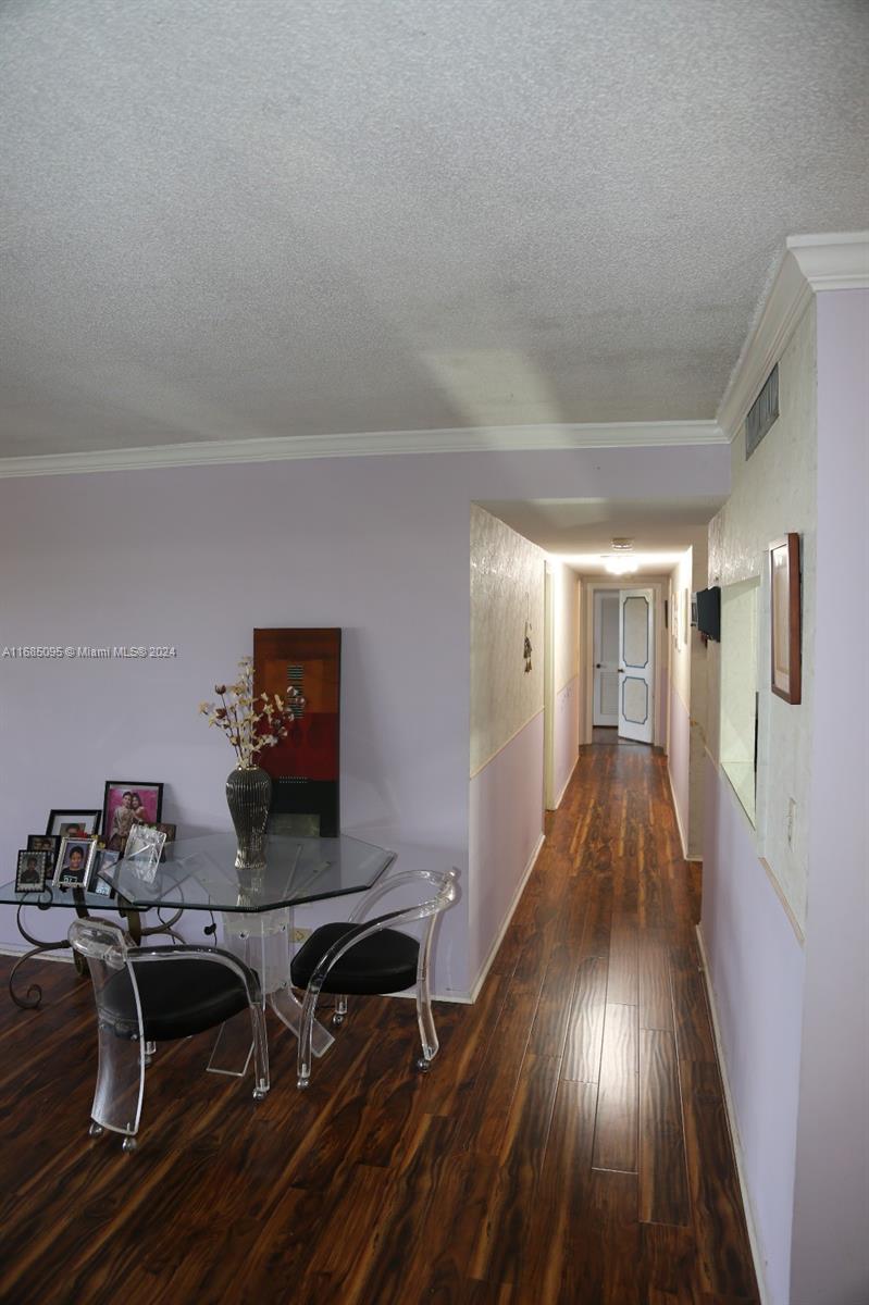 800 Northeast 195th Street, Unit 501 Miami, FL 33179 - Photo 10 of 39 a hallway with wooden floor book shelf and table