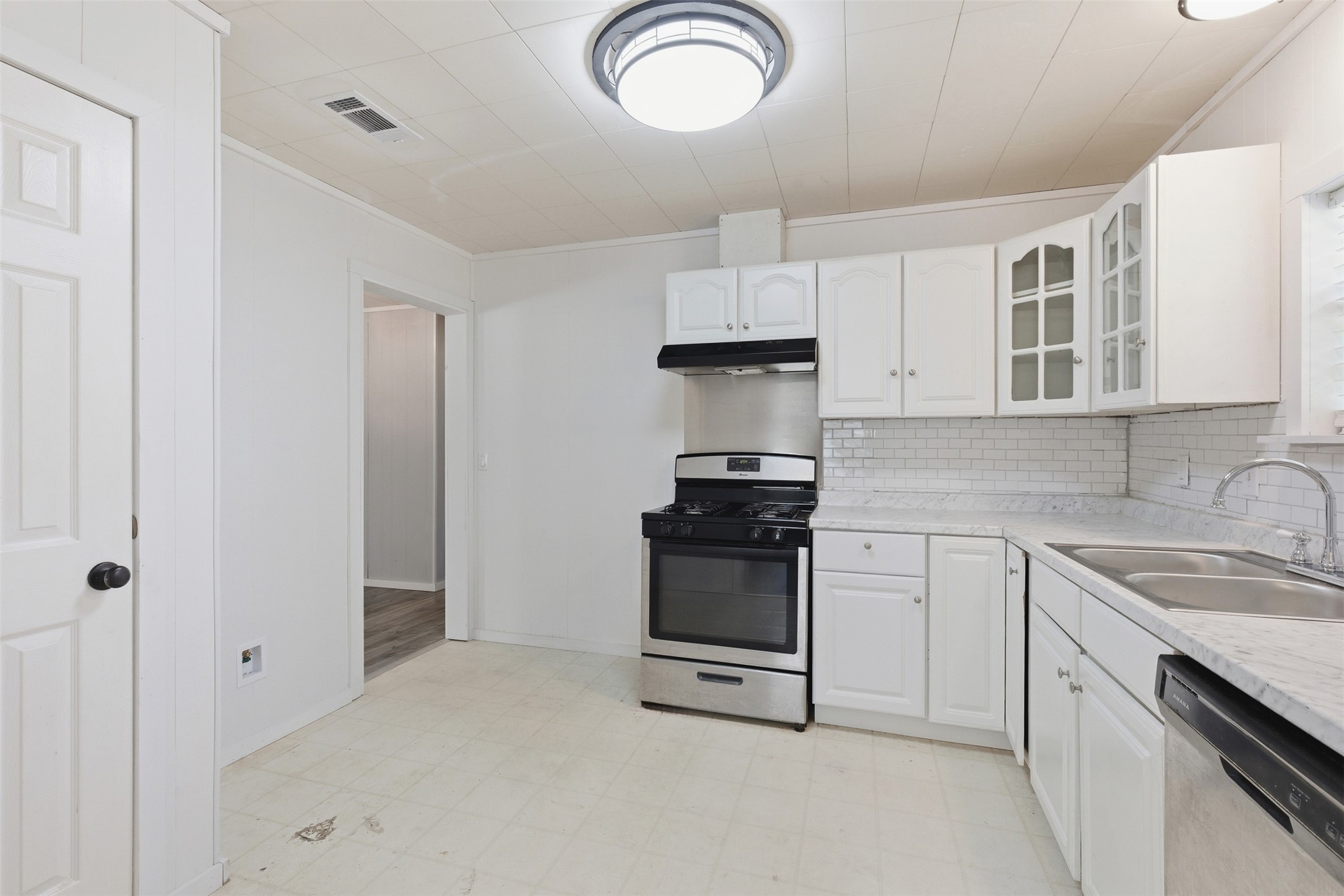1310 Brazos Street Hempstead, TX 77445 - Photo 9 of 32 a kitchen with stainless steel appliances granite countertop a sink stove and cabinets