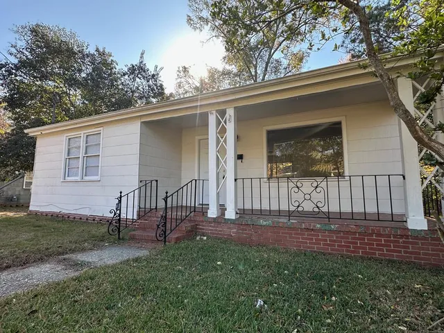 a view of a house with backyard and a tree