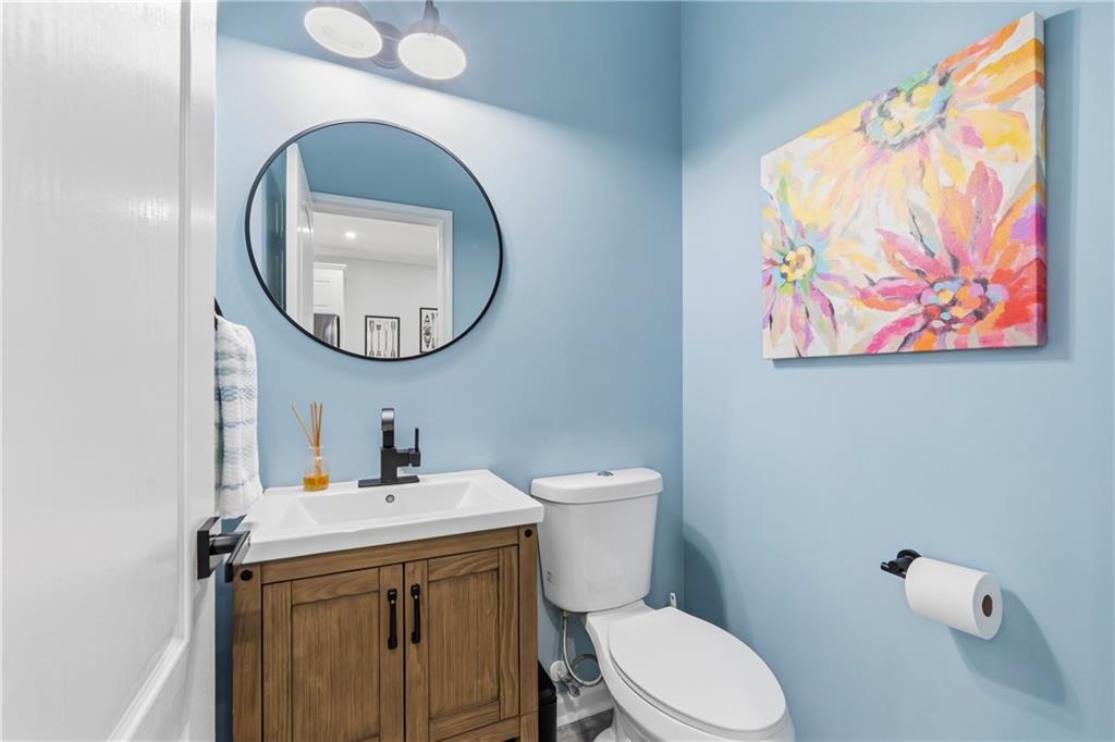 549 Old Phoenix Road Northeast, Unit 104 Eatonton, GA 31024 - Photo 20 of 49 a bathroom with a toilet a sink and a mirror
