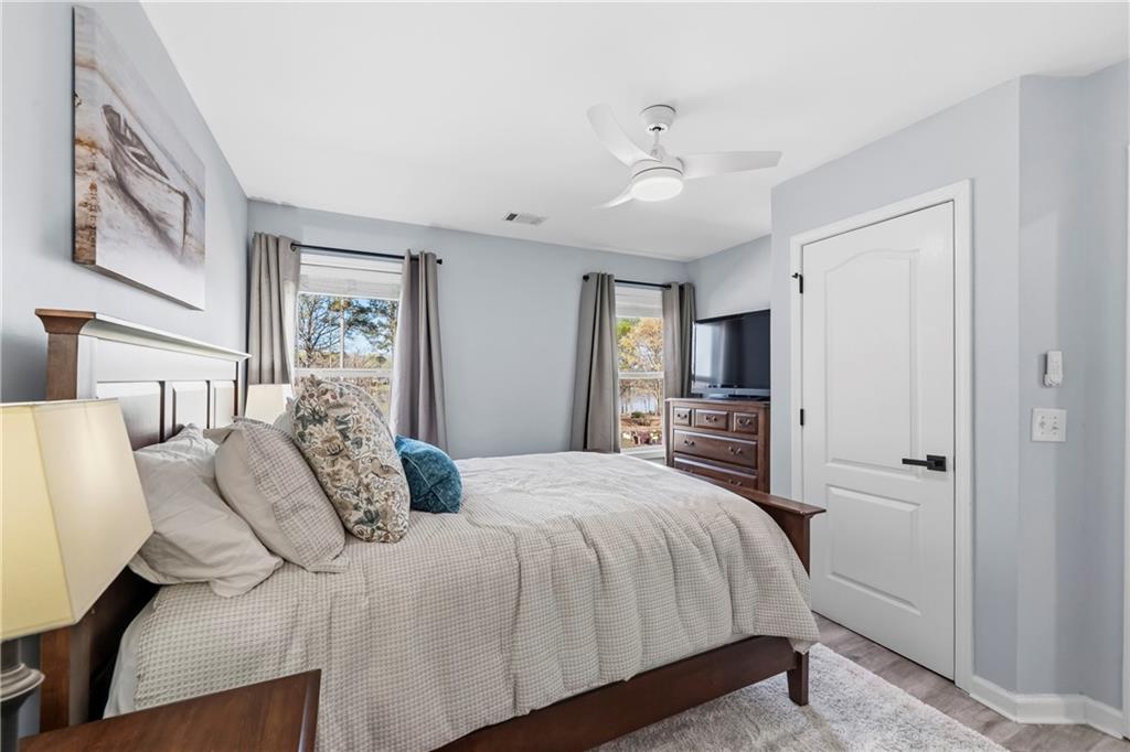 549 Old Phoenix Road Northeast, Unit 104 Eatonton, GA 31024 - Photo 25 of 49 a bedroom with a large bed and a chandelier