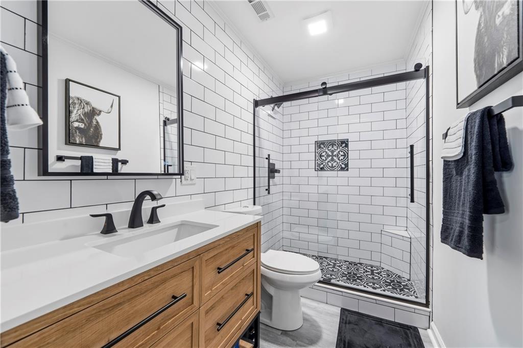 549 Old Phoenix Road Northeast, Unit 104 Eatonton, GA 31024 - Photo 26 of 49 a bathroom with a sink a toilet and shower
