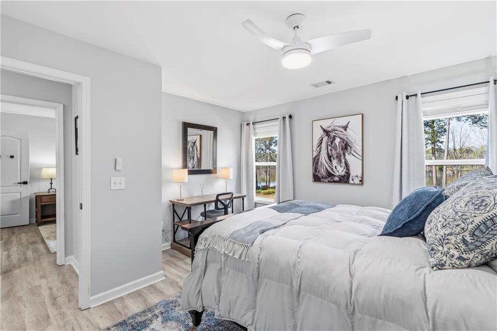 549 Old Phoenix Road Northeast, Unit 104 Eatonton, GA 31024 - Photo 29 of 49 a bedroom with a large bed and a chandelier