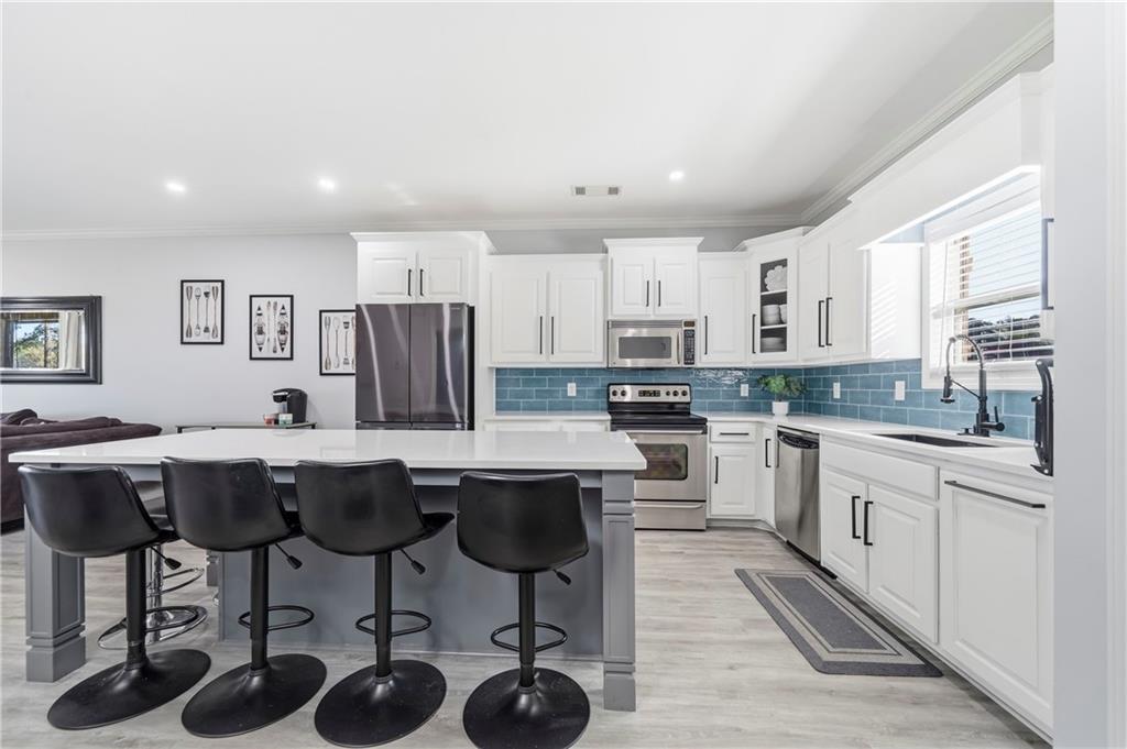 549 Old Phoenix Road Northeast, Unit 104 Eatonton, GA 31024 - Photo 5 of 49 a kitchen with a sink a counter top stainless steel appliances and cabinets