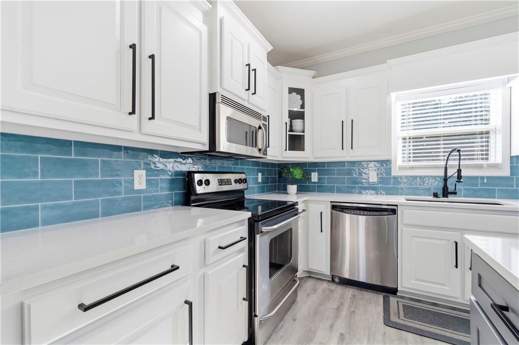 549 Old Phoenix Road Northeast, Unit 104 Eatonton, GA 31024 - Photo 7 of 49 a kitchen with stainless steel appliances granite countertop a sink a stove and cabinets