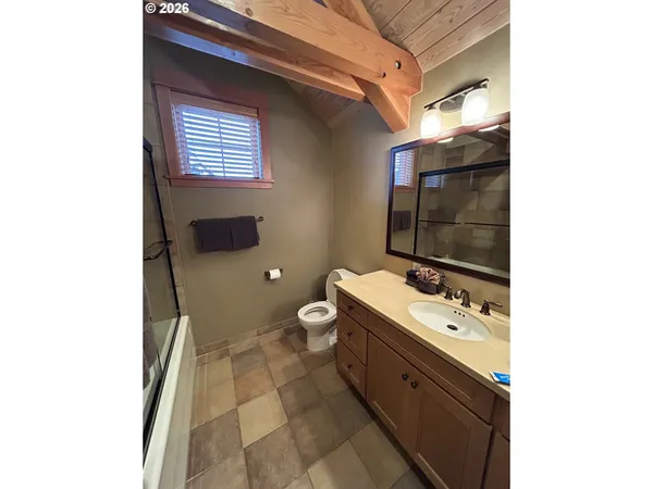 a spacious bathroom with a toilet sink and mirror