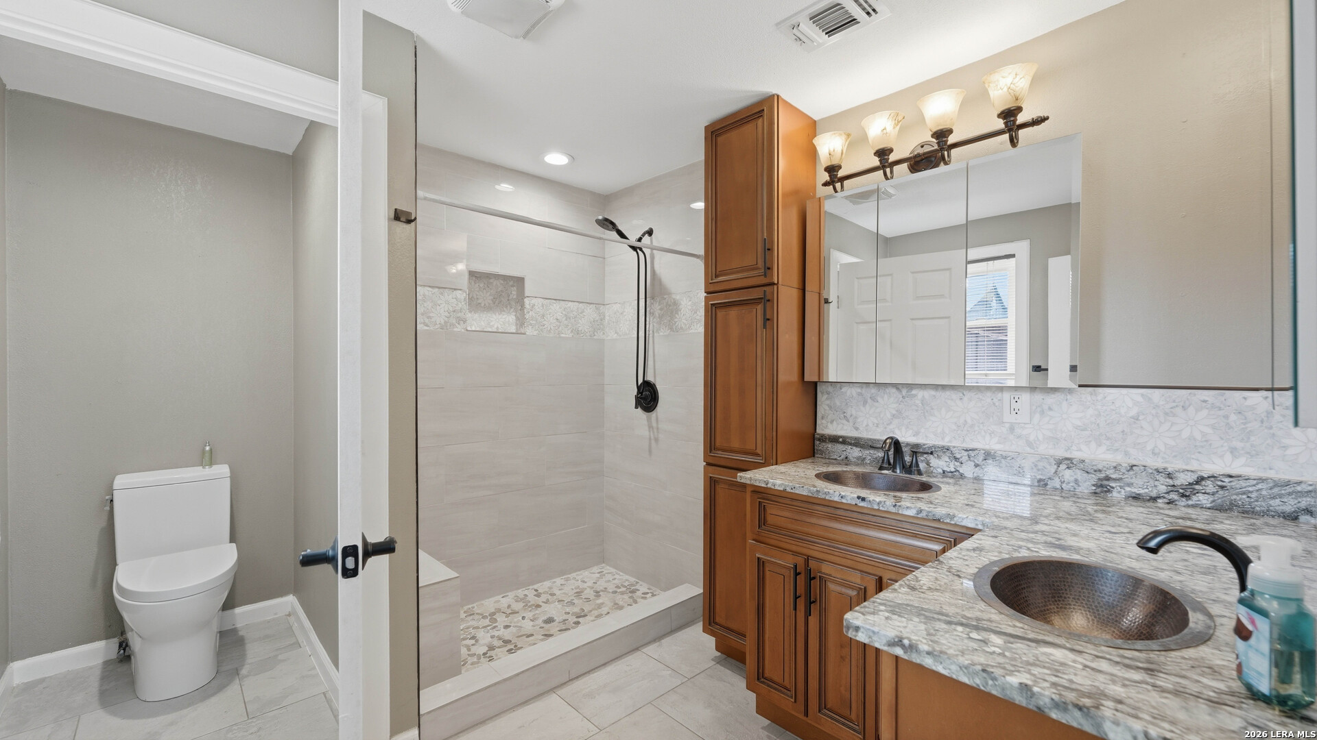 106 County Road 6611 Devine, TX 78016 - Photo 11 of 29 a bathroom with a granite countertop sink toilet and shower
